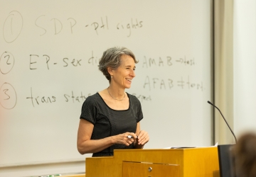 Clare Huntington behind podium and in front of a whiteboard
