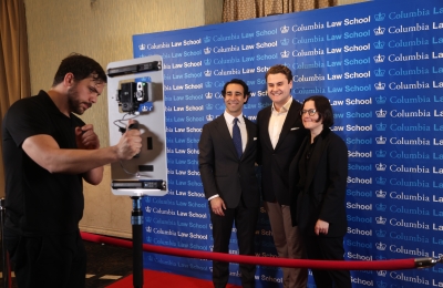 Two men and a woman being photographed in front of a backdrop