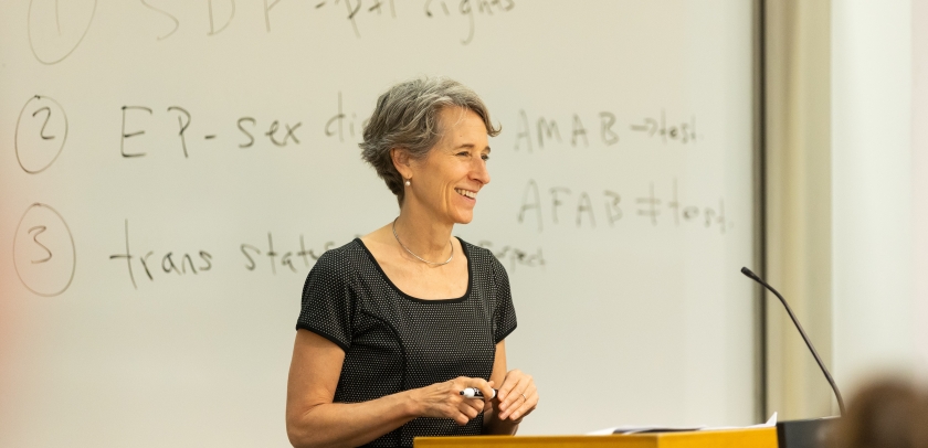 Clare Huntington behind podium and in front of a whiteboard