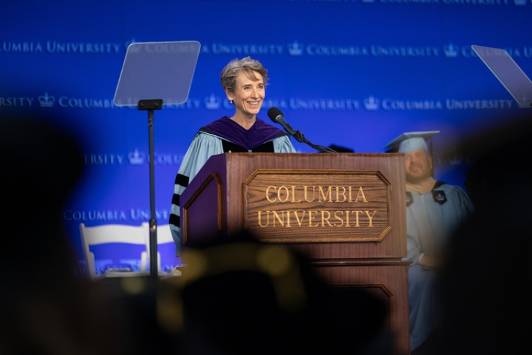 Clare Huntington in academic regalia at podium