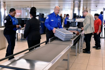 Man in blue uniform at airport security checkpoint