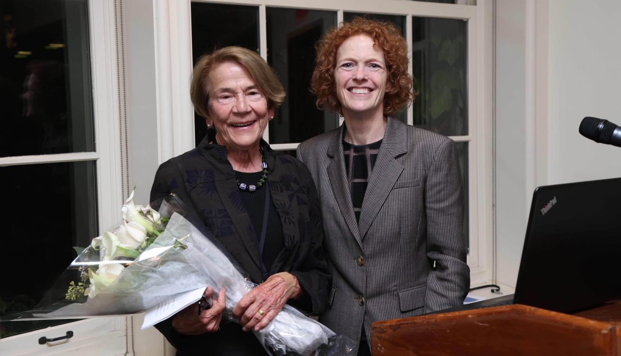 Two women smiling, one with bouquet of flowers