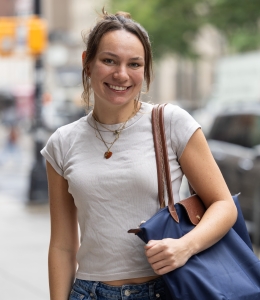 Isabel Manning in light colored T-shirt carrying a blue tote bag on her shoulder