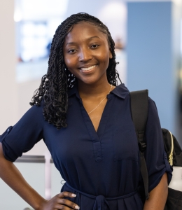 Naya Welcher in dark blue dress with backpack strap over one shoulder