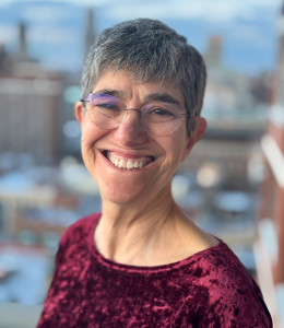 Woman in a red shirt and glasses smiling