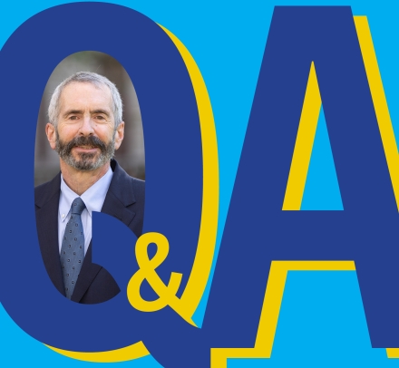 Q&A graphic with photo of bearded man in a suit.