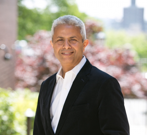 Silver-haired man in white collared shirt and black blazer