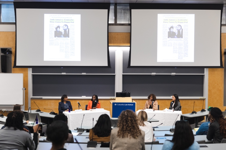 A panel of speakers in a classroom