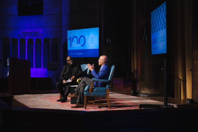 Two men in armchairs on a stage at Columbia Law School